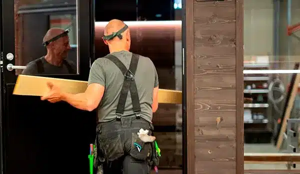 Kotimainen puuseppä rakentamassa Lapelland-saunaa tehtaalla Pyhännällä. Laadukas käsityö ja valmistus kuivissa sisätiloissa takaavat kestävyyden.